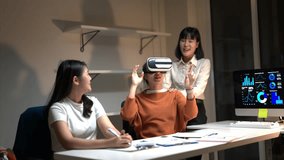 Three women are sitting at a desk with a computer monitor in front of them. One of the women is wearing a VR headset and is looking at the monitor. The other two women are looking at her - Powered by Shutterstock - Get 15% off with code: PIKWIZARD15