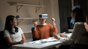 Three women are sitting at a table, one of them wearing a virtual reality headset. They are all smiling and seem to be enjoying themselves - Powered by Shutterstock - Get 15% off with code: PIKWIZARD15