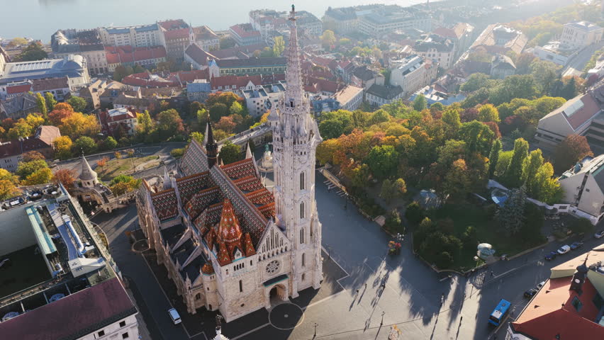 The vibrant roof tiles of Matthias Church shine brightly in this aerial shot, highlighting its intricate Gothic design beside Fisherman’s Bastion.
