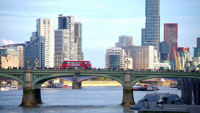 Westminster Bridge over the Thames in London, UK, with multiple buses and city traffic, perfect for travel, cityscape, and urban lifestyle content.