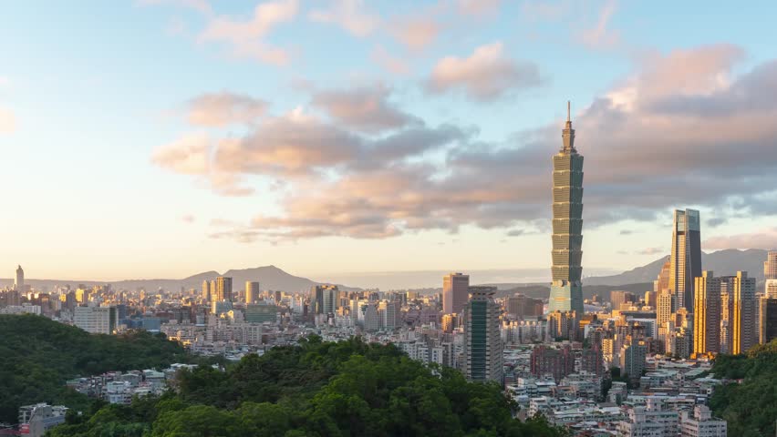 Aerial view of a city skyline with a Taipei tall tower surrounded by urban greenery.