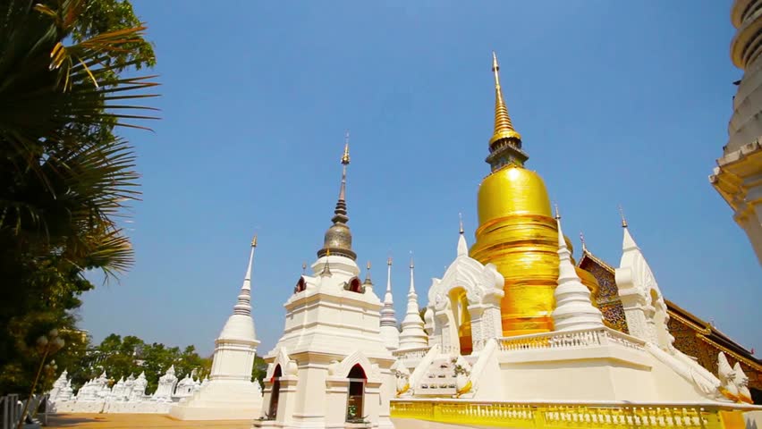 Golden pagoda at Wat Suan Dok temple complex in Chiang Mai under a clear blue sky