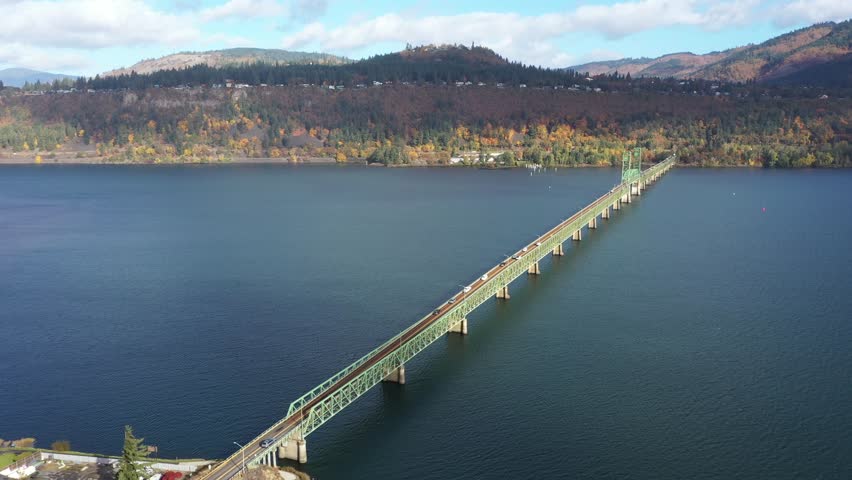 4K aerial drone footage of Hood River Bridge in Oregon showing light morning traffic on a sunny fall day. Scenic view of Columbia River with autumn colors and calm water in the Pacific Northwest 