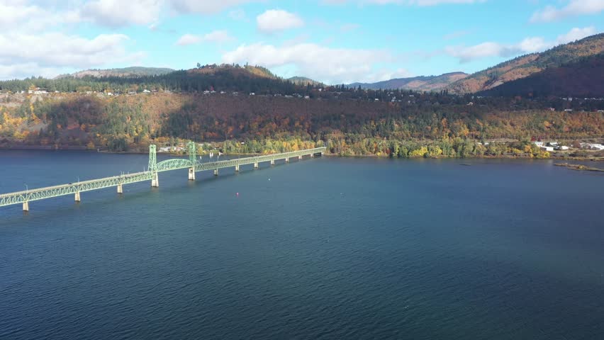 4K aerial drone footage of Hood River Bridge in Oregon showing light morning traffic on a sunny fall day. Scenic view of Columbia River with autumn colors and calm water in the Pacific Northwest 