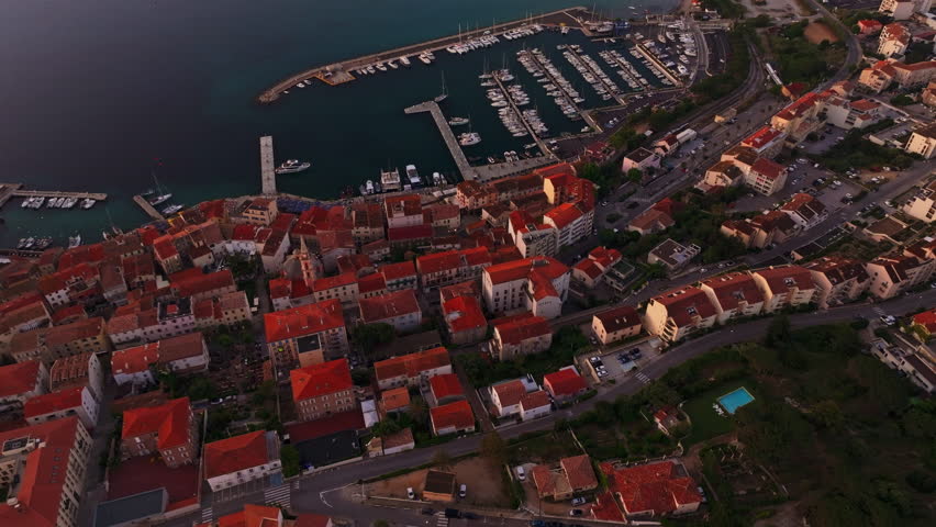 Top down aerial drone shot over the historic town of Calvi in Corsica, France High view of the harbor and red rooftops. Summer holidays destination