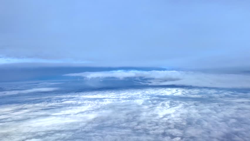 An immersive pilot’s perspective from the cockpit of a jet flying peacefully between layers of ethereal clouds with the sun rays piercing the clouds