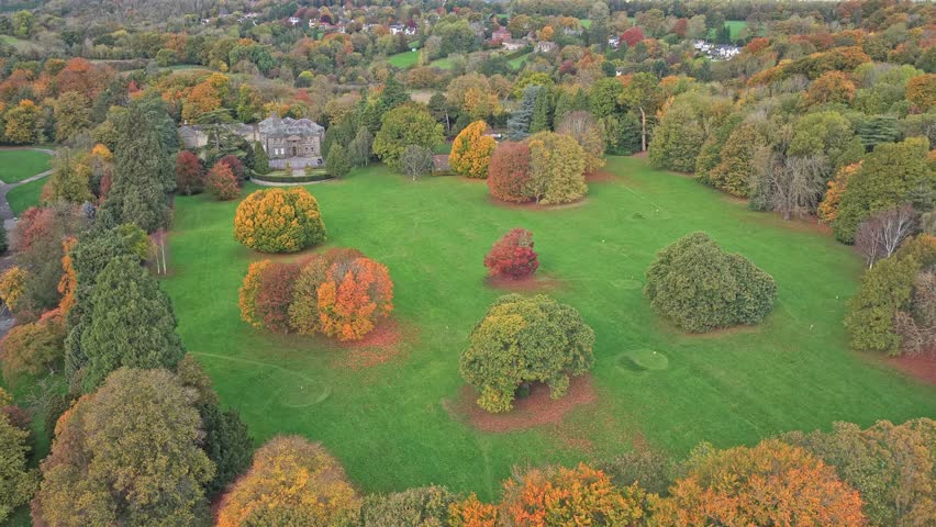 Aerial view of Conyngham Hall Business Centre, a historic mansion surrounded by autumn foliage and mature trees in Knaresborough, North Yorkshire, UK. Parkland setting with tranquil nature.
