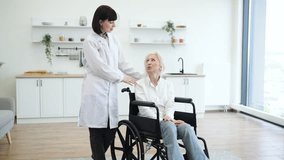 A female doctor in a white coat speaks with an elderly woman sitting in a wheelchair indoors. - Powered by Shutterstock - Get 15% off with code: PIKWIZARD15