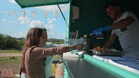 Smiling bartender serving a glass of white wine to a young couple at a food truck during an event - Powered by Shutterstock - Get 15% off with code: PIKWIZARD15