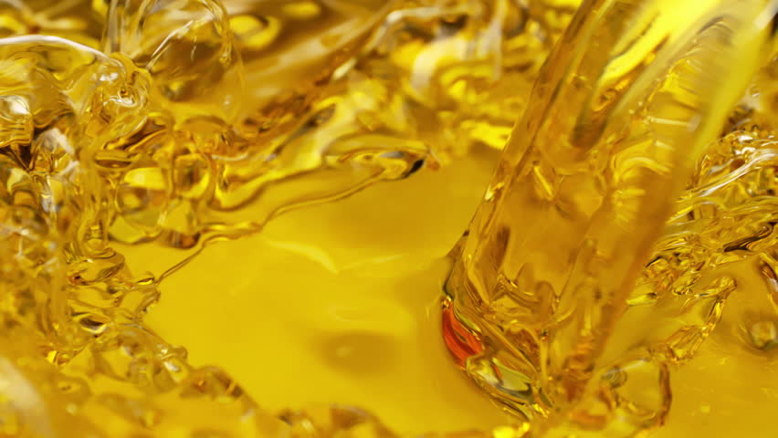 Super Slow Motion Shot of Pouring and Splashing Golden Oil Liquid at 1000fps.