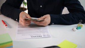 Close-up of a businessmans hands counting cash on a table next to a printed hotel registration form. This clip represents travel planning, business trips, budgeting for expenses, and traditional - Powered by Shutterstock - Get 15% off with code: PIKWIZARD15