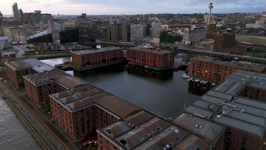 Royal Albert Dock at twilight. Illuminated warehouses and calm water of docks, Liverpool, UK. Aerial drone view