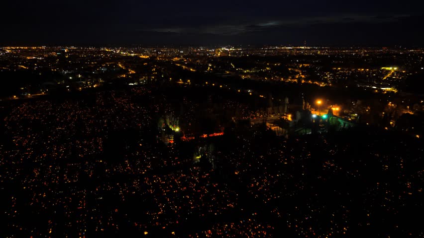 Aerial view of the Mirogoj Cemetery illuminated by candles forming a cross, casting a warm glow against the dark night, Grad Zagreb, Croatia.