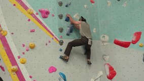 Man Climbing Boulder Wall In The Gym - Tracking Shot - Powered by Shutterstock - Get 15% off with code: PIKWIZARD15