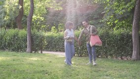 Young multiracial couple walking together, holding hands and sharing intimate moments while strolling through lush green park, expressing joyful connection and romantic relationship - Powered by Shutterstock - Get 15% off with code: PIKWIZARD15