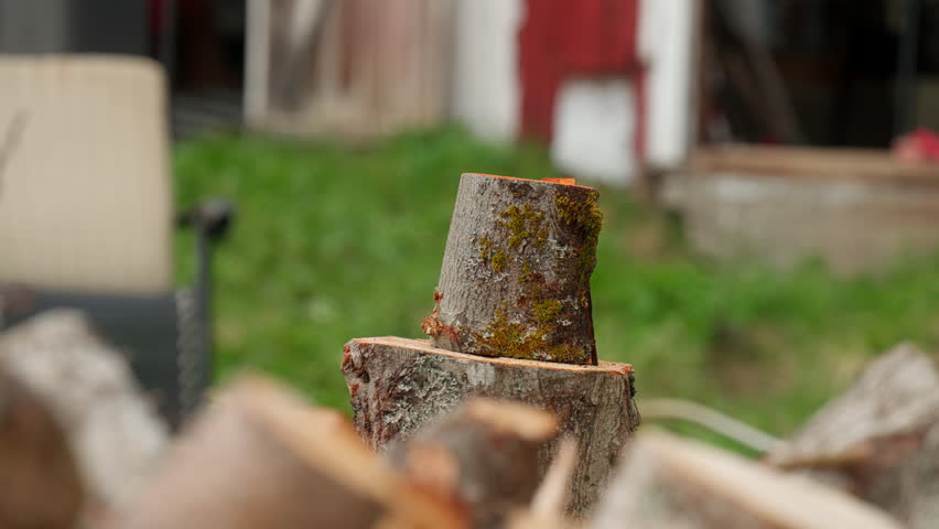 Slow-motion close-up of a person chopping firewood with an axe, capturing the impact as the log splits apart, showing strength, craftsmanship, and rural outdoor lifestyles