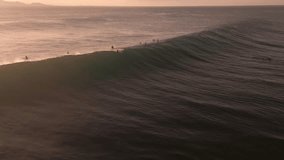 Dusklit surfers paddle towards massive barrels, drone captures surfers surfing monumental waves - Powered by Shutterstock - Get 15% off with code: PIKWIZARD15