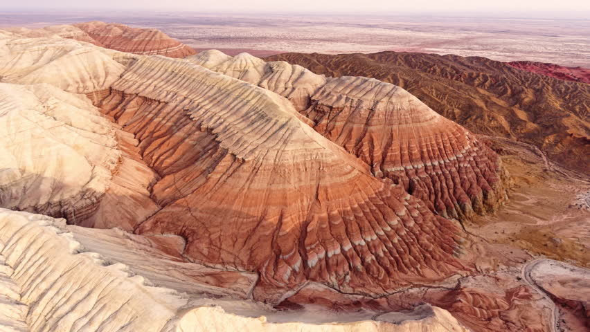 Aerial view of colorful striped layered sedimentary mountains and unique erosion geological pattern in Altyn Emel national park, Kazakhstan