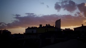 Colorful evening sky with dramatic clouds and sun rays shining over urban rooftops, symbolizing peace, beauty, and the end of the day. - Powered by Shutterstock - Get 15% off with code: PIKWIZARD15