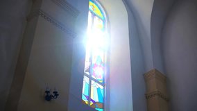 Sunlight streams through a vibrant stained-glass window, casting colorful patterns on the wall. Arched window with intricate stained glass illuminated by a bright sunbeam.	 - Powered by Shutterstock - Get 15% off with code: PIKWIZARD15