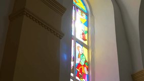 Sunlight streams through a vibrant stained-glass window, casting colorful patterns on the wall. Arched window with intricate stained glass illuminated by a bright sunbeam.	 - Powered by Shutterstock - Get 15% off with code: PIKWIZARD15