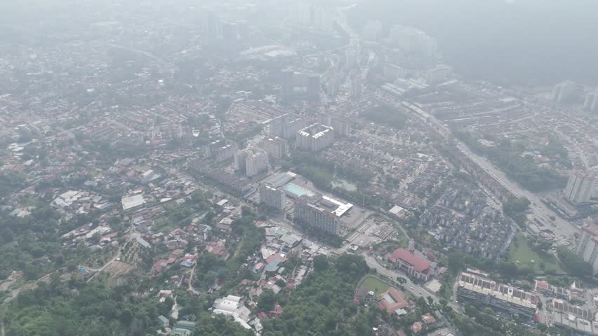 Aerial view of a city in Penang blanketed in thick haze, illustrating urban air pollution and environmental issues affecting visibility and public health in metropolitan areas.