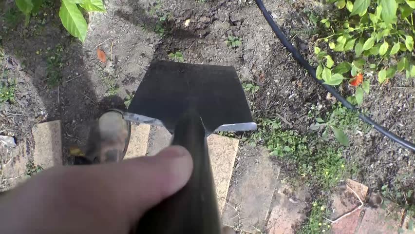 digging a hole in the garden with a spade pov 