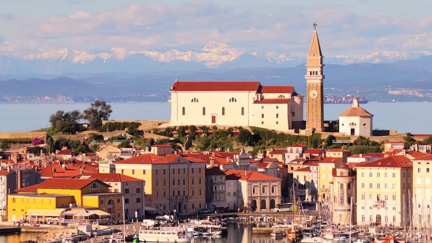 Aerial view of Piran city, St. George Church, Alps in distance, travel vibe