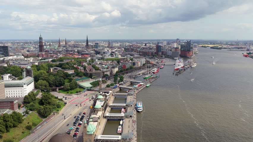 Aerial perspective of city of Hamburg, showing bustling port on Elbe River with famous Landungsbruecken piers with ferris