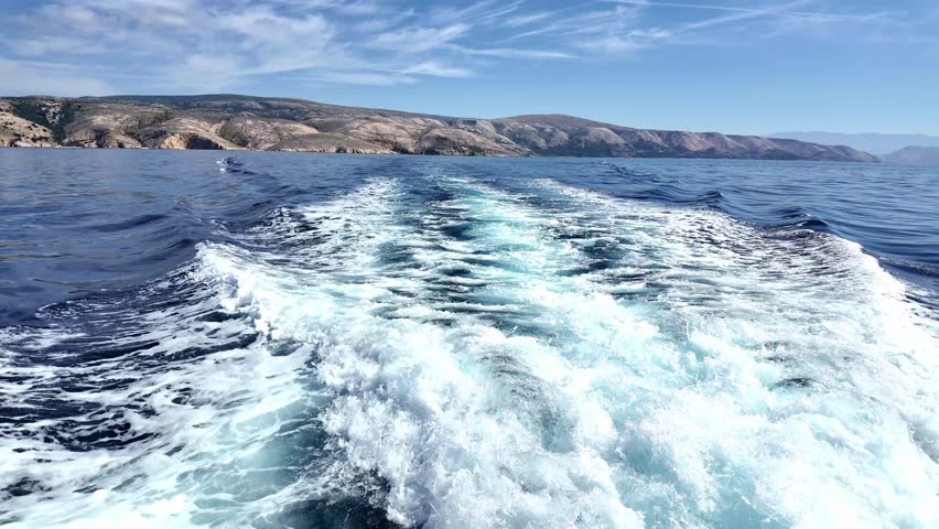 Scenic ocean wake trail creates vivid ocean scenes under bright sky.