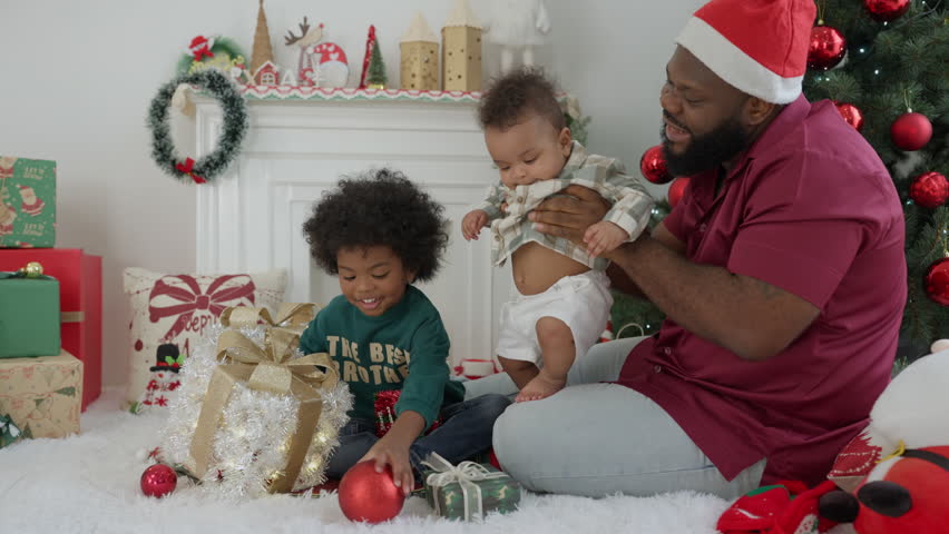 Happy African American dad with two son children celebrating Christmas. Black father and kids opening Christmas gifts.