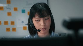 Young Asian Female Call Center Customer Service Agent Providing Helpline Support, CRM Consultation, Telemarketing and Remote Online Communication and Customer Care Service with Clients at Office. - Powered by Shutterstock - Get 15% off with code: PIKWIZARD15