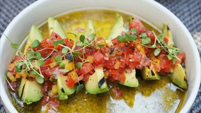 Close-up shot of a woman eating fresh avocado with sliced tomatoes, showcasing healthy eating, fresh ingredients, and a nutritious lifestyle focused on natural and wholesome food. - Powered by Shutterstock - Get 15% off with code: PIKWIZARD15