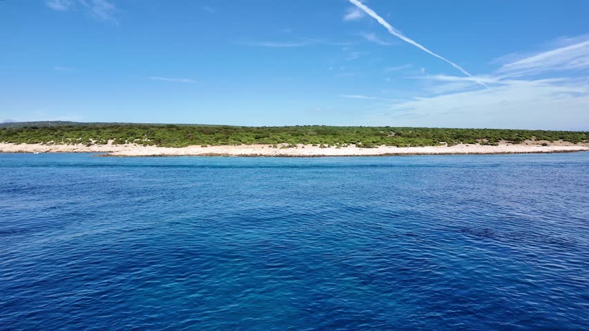 Aerial view of tranquil coastal waters and scenic shoreline under clear skies.