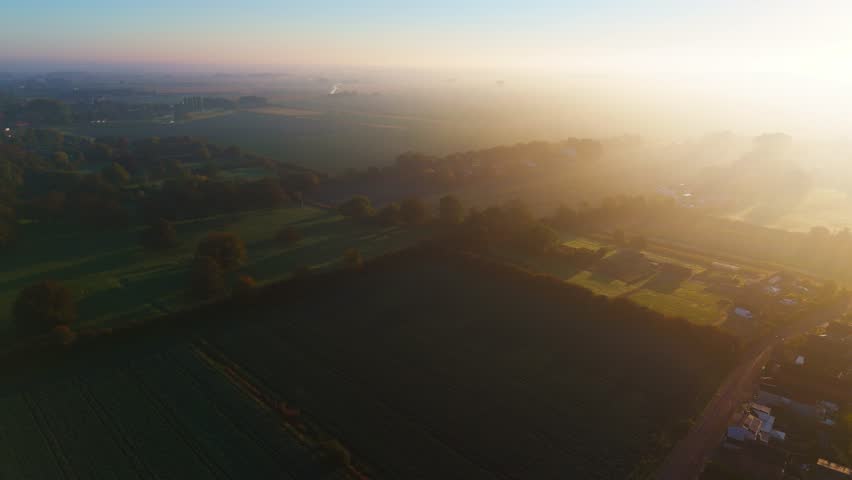 Misty autumn morning with farmlands and countryside views, wide vistas across open fields with crops set for overwintering. cold days in a rural village setting