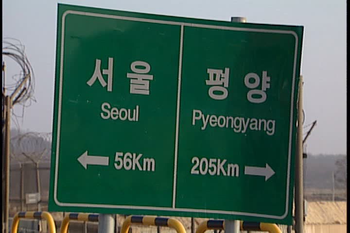  General views of the Korean Demilitarized Zone or DMZ; CU green and white road sign giving directions and mileage to both Seoul and Pyeonggyang Korea. 