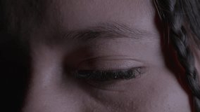 Intimate close-up of a woman's eye, framed by a delicate braid. The moody, dramatic lighting highlights the texture and emotion in this captivating portrait shot. - Powered by Shutterstock - Get 15% off with code: PIKWIZARD15