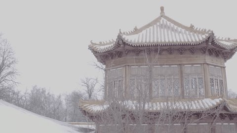 Drone Ascending above Snow Covered Chinese Temple Pavilion