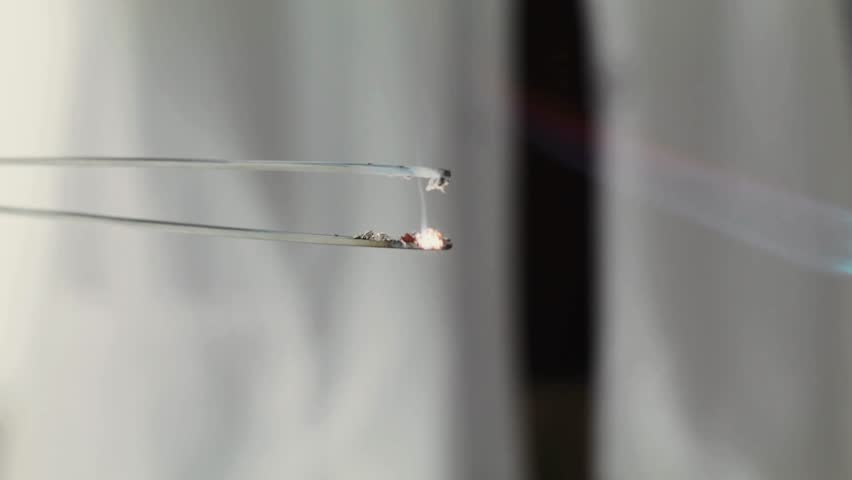 Close-up 4K Ultra HD footage of a combustion reaction, showing flames, sparks, and chemical energy release during a controlled scientific experiment in a laboratory setting.