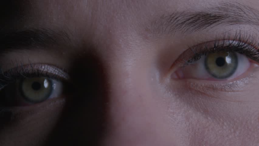 Intimate close-up of a girl's focused eyes capturing deep emotion and intensity. The ambient lighting casts soft shadows, highlighting texture for a moody cinematic effect.