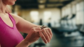 Smart watch using in gym, Close up of woman hands im gym checking incoming notification on smart watch. Incoming text message received on app smartwatch. Social media networking technology concept. - Powered by Shutterstock - Get 15% off with code: PIKWIZARD15