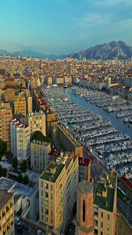  Many boats and yachts are parked in the city marina. Aerial view of the port of Marseille in the morning sun. Drone view of Marseille in the south of France