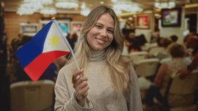 Blonde woman holding a philippine flag in a crowded art gallery during an exhibition; pride celebration cultural joy. - Powered by Shutterstock - Get 15% off with code: PIKWIZARD15