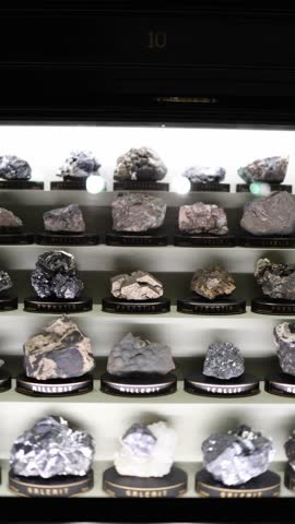 Vertical screen minerals pyrrhotite millerite nicoline and galenite displayed in illuminated museum case geological collection of metallic crystals showing natural formations and earth science beauty