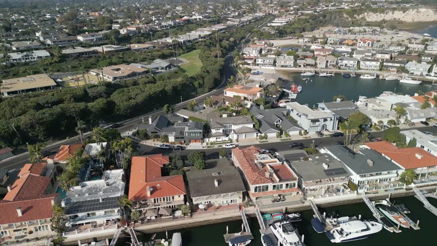 Wide aerial drone shot of Costa Mesa California beach coastline with oceanfront sandy shore and scenic sky in Orange County USA