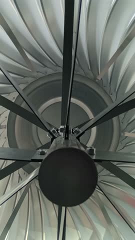 A view from inside an air duct showing a rotating deflector and stainless steel grille in a ventilation system design for an industrial restaurant building.