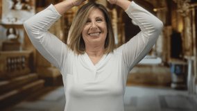 Woman smiling raises arms overhead in church nave interior wearing white shirt and looks upward at stone columns; serenity. - Powered by Shutterstock - Get 15% off with code: PIKWIZARD15