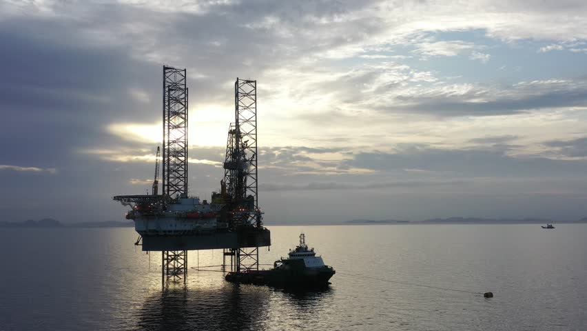 Aerial view of offshore jack up rig and offshore platform during sunset for oil and gas exploration and production. 
