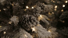 Snowy pinecones on frosted Christmas tree with glowing lights in festive setting - Powered by Shutterstock - Get 15% off with code: PIKWIZARD15