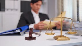 Asian lawyer working with gavel and scales of justice in courtroom office. Attractive attorney reviews papers and documents at desk, representing law and legal business services concept in workplace. - Powered by Shutterstock - Get 15% off with code: PIKWIZARD15
